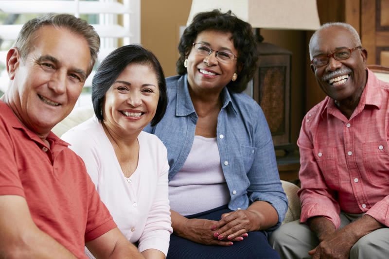 A group of people sitting around each other.