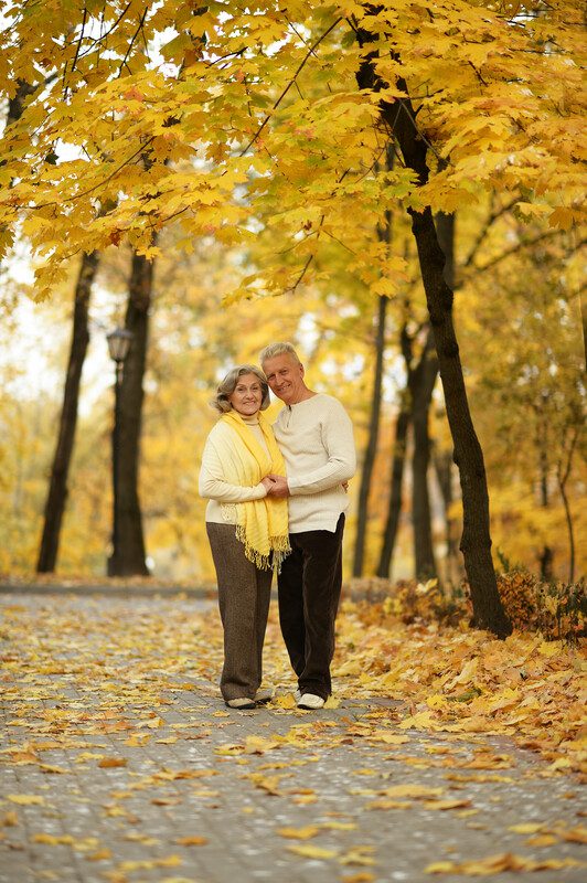 A man and woman standing in the middle of a park.