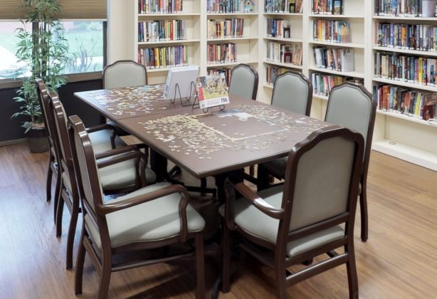 A table with chairs and books in the background.