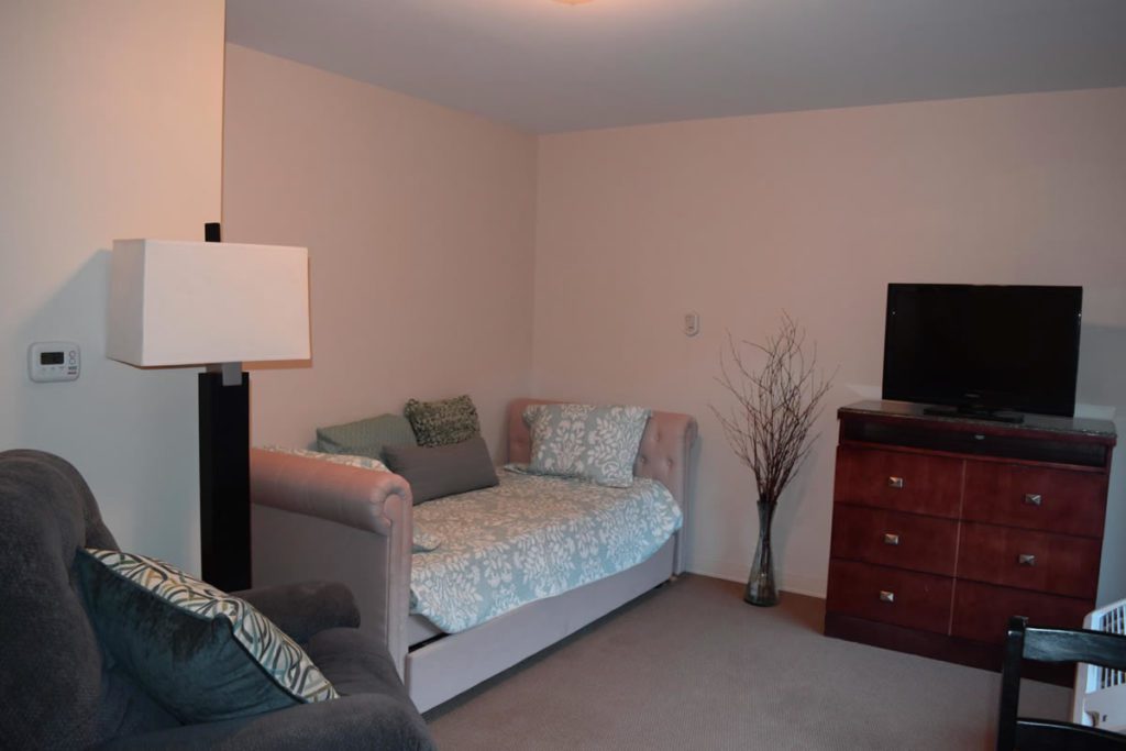 A bedroom with a couch and television in it