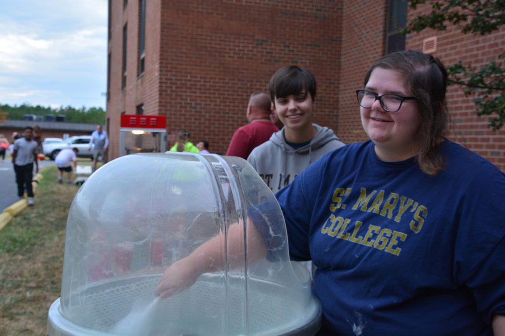 Two people standing next to a glass dome.