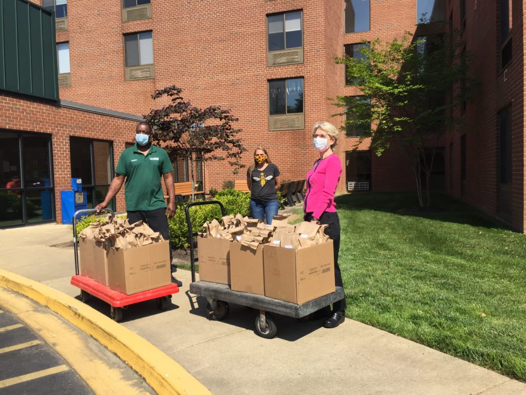 A group of people standing around with boxes.