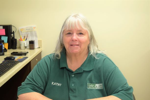 A woman in green shirt sitting down with her arms crossed.