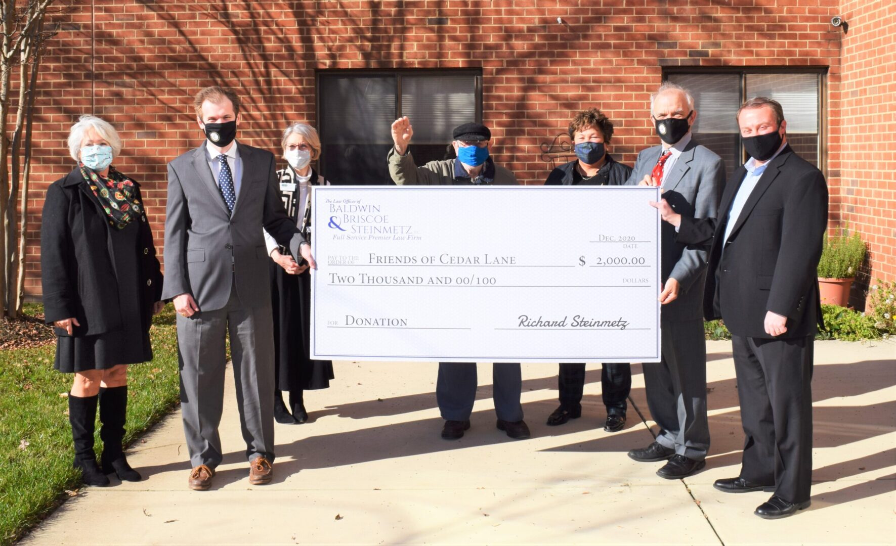 A group of people holding up a large check.