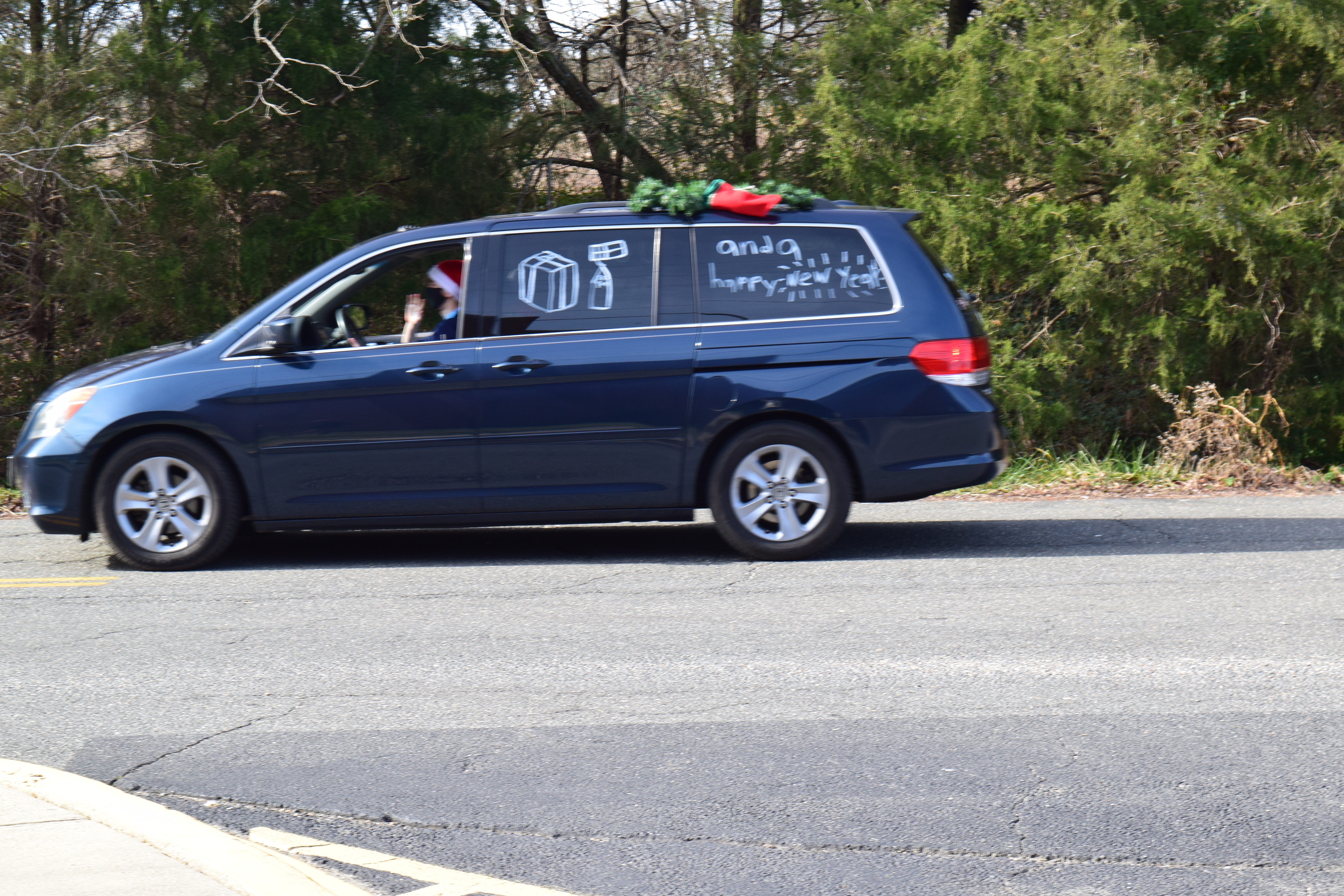 A blue van with christmas decorations on the top of it.