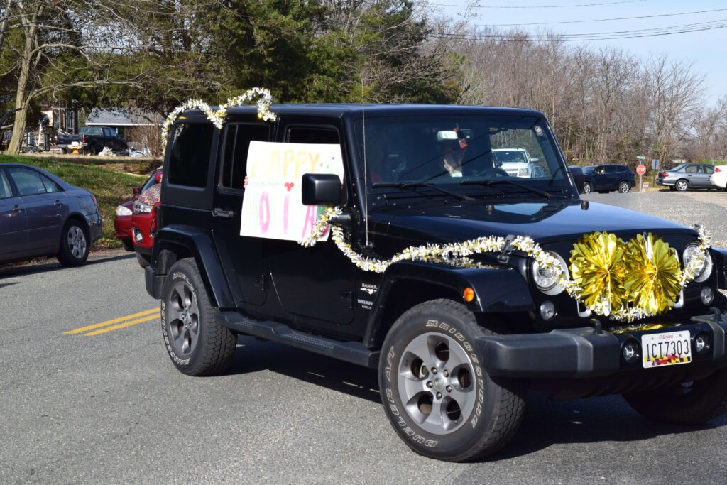 A black jeep with flowers on the side of it.