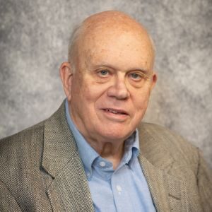 A man in a suit and tie with a gray background