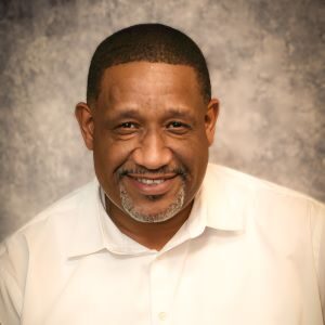 A man in white shirt and black beard.