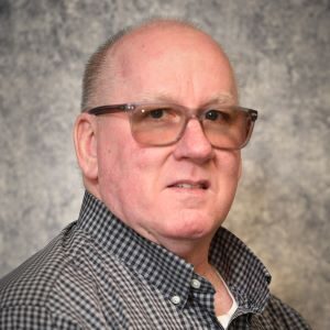 A man with glasses and a plaid shirt.