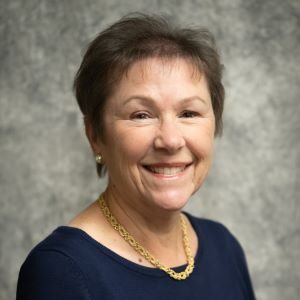 A woman with short hair and wearing a necklace.