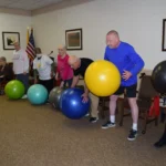 A group of people standing around some balls