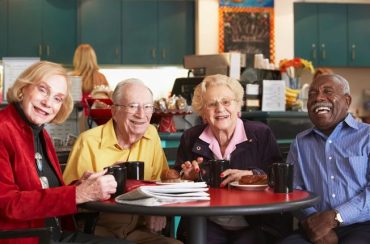 A group of people sitting at a table drinking coffee.